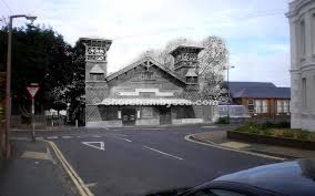 The ornate Victorian gateway lodge at the Victoria Road entrance to Swiss Gardens, surviving in the modern street scene.